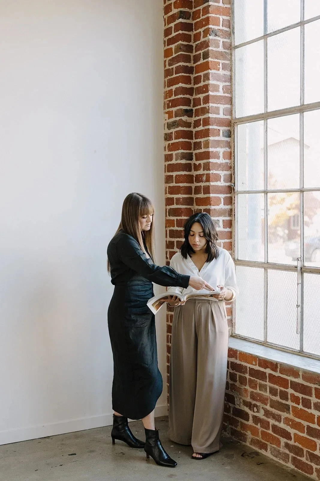 Courtney and Alexa collaborating on a wedding design in their studio