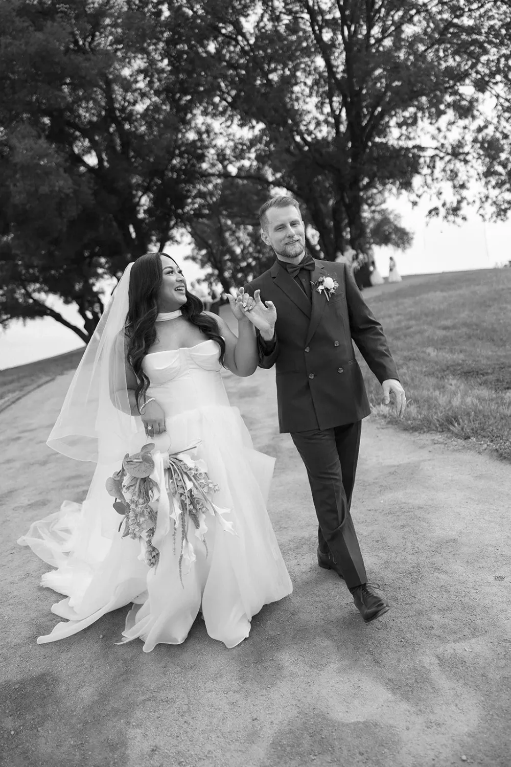 Newlyweds walking together after their ceremony in black and white